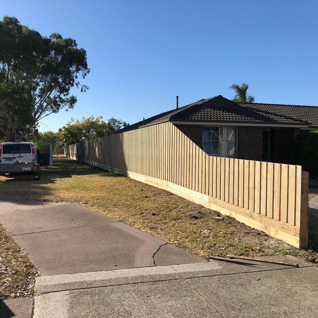 New timber paling boundary fence with plinth boards along a street frontage, Levers Fencing van parked behind